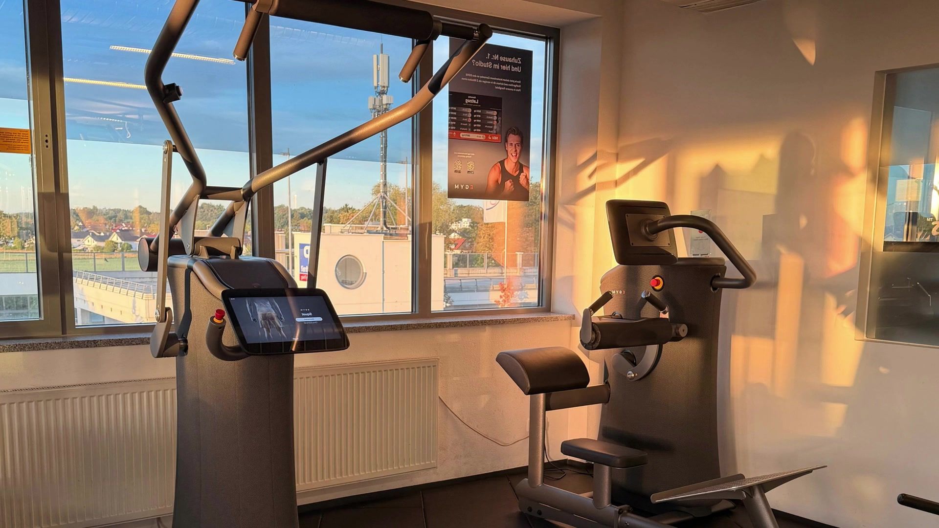 EGYM-Gerät mit Bildschirm im Abendlicht am Fenster des Studios
