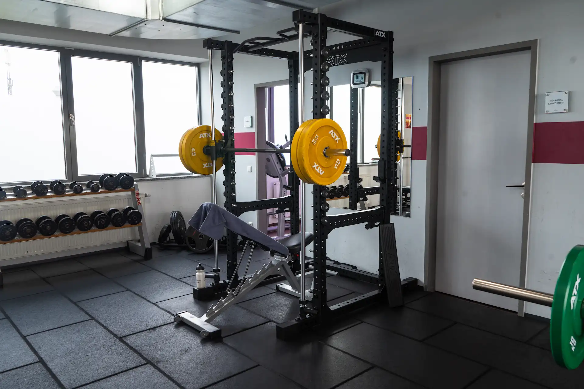 Power-Rack mit Langhantel und Hantelscheiben im Freihantelbereich