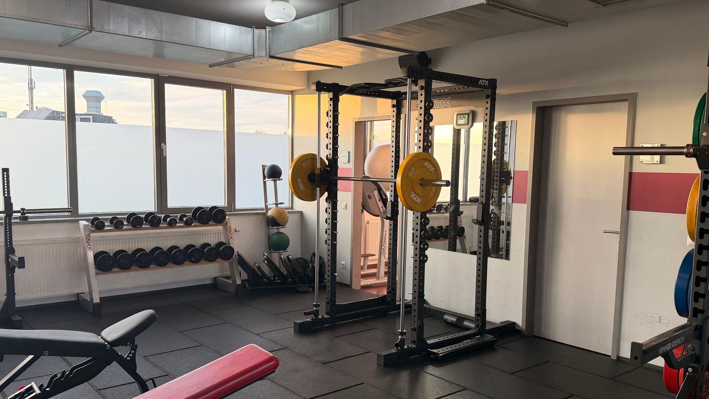 Kraftbereich mit Power-Racks, Langhanteln und Kurzhanteln am Fenster