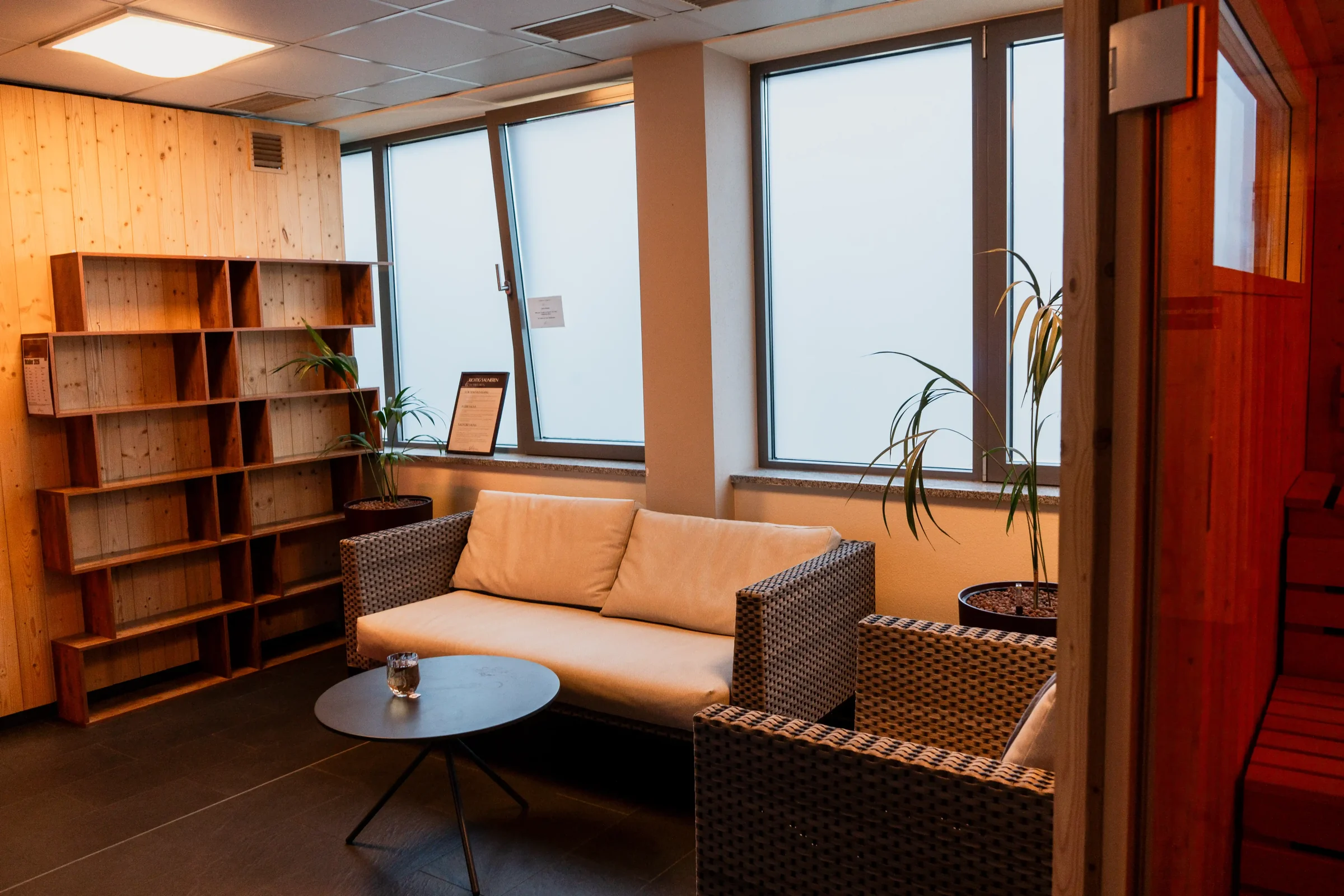 Sitzecke mit Sofa und Holzregal im Wellnessbereich